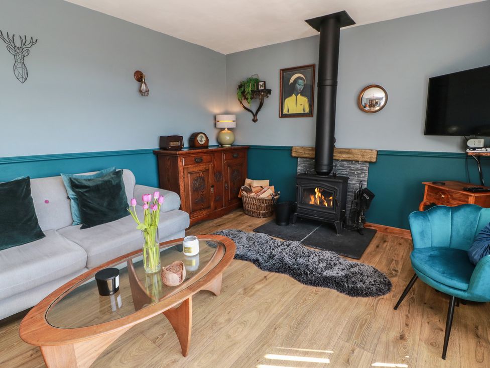 A living room with a fireplace and sofa at Crown Cottage in Newmills near Cairneyhill