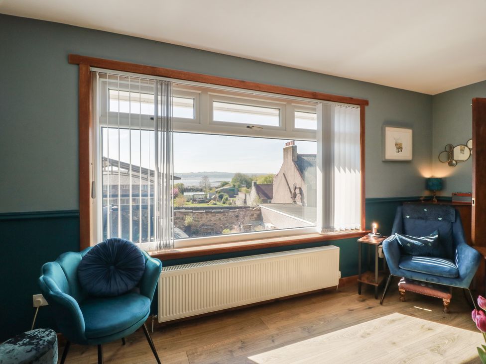 A living room with a view and chairs at Crown Cottage Newmills near Cairneyhill