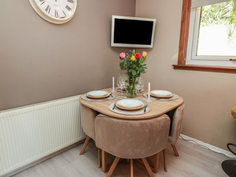 A dining room with a table and chairs set for a meal at Crown Cottage in Newmills near Cairneyhill