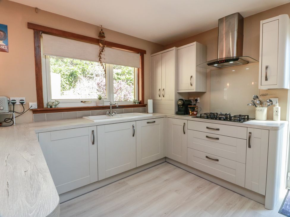 A kitchen with cabinets and a sink at Crown Cottage in Newmills near Cairneyhill