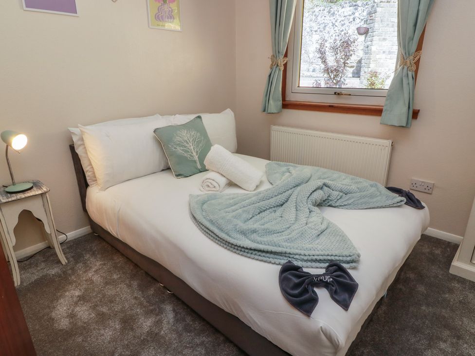 A bedroom with a bed and lamp at Crown Cottage Newmills near Cairneyhill