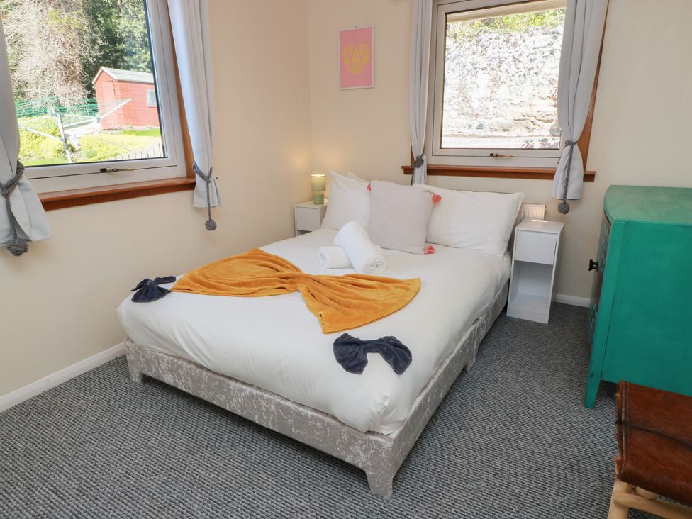 A bedroom with a bed and nightstand at Crown Cottage, Newmills near Cairneyhill