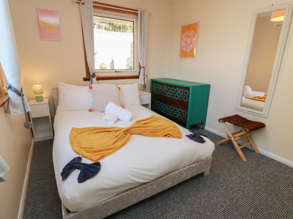 A bedroom with a bed and nightstand at Crown Cottage Newmills near Cairneyhill