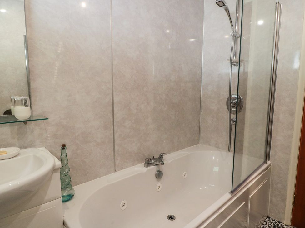 A bathroom with a bathtub and sink at Crown Cottage Newmills near Cairneyhill