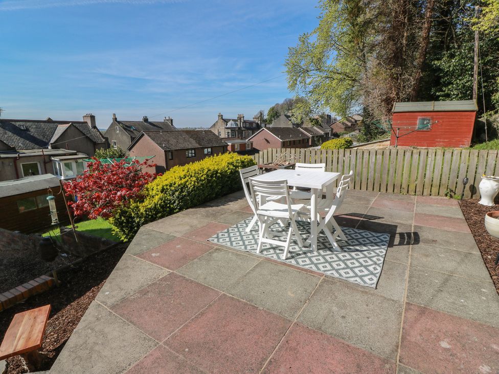 A garden with a table and chairs on a patio at Crown Cottage in Newmills near Cairneyhill