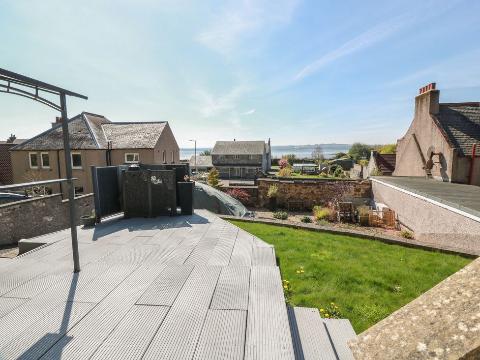 An outdoor area with decking and a view of houses and garden at Crown Cottage Newmills near Cairneyhill