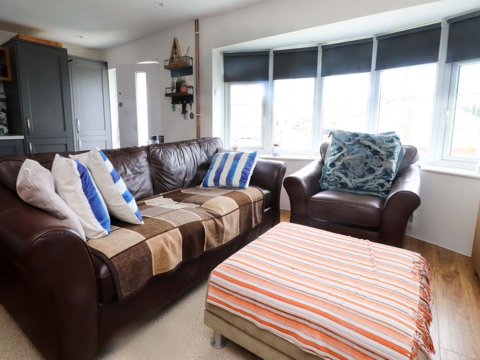 A living room with a sofa and ottoman at 7 Sisial Y Mor Rhosneigr