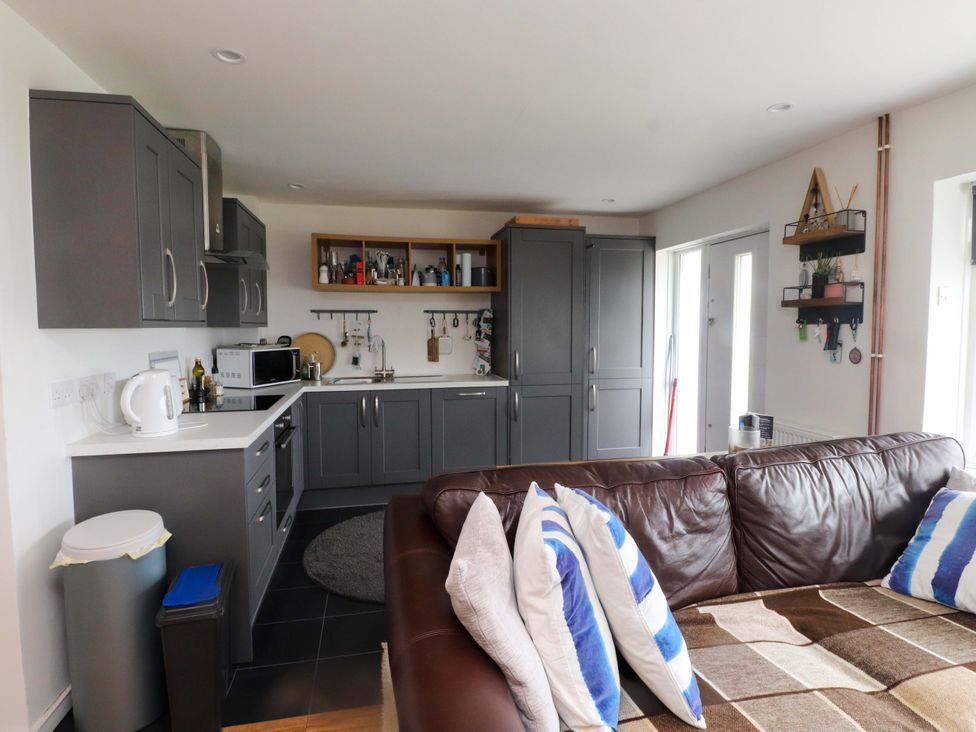 A kitchen with a sofa and appliances at 7 Sisial Y Mor Rhosneigr