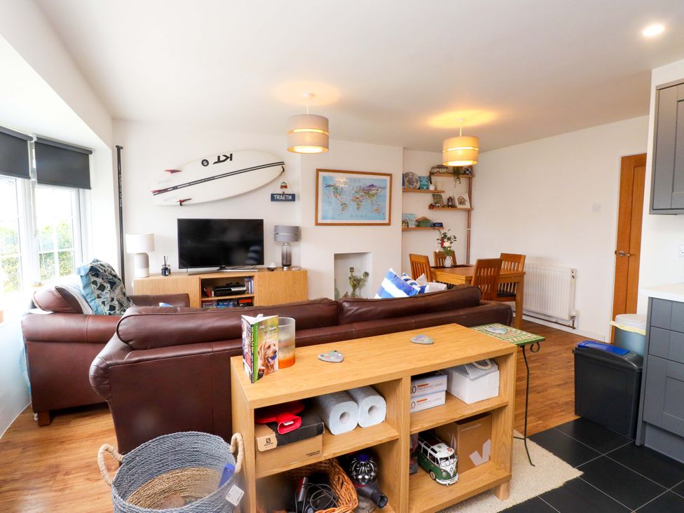 A living room with a television and dining table at 7 Sisial Y Mor in Rhosneigr