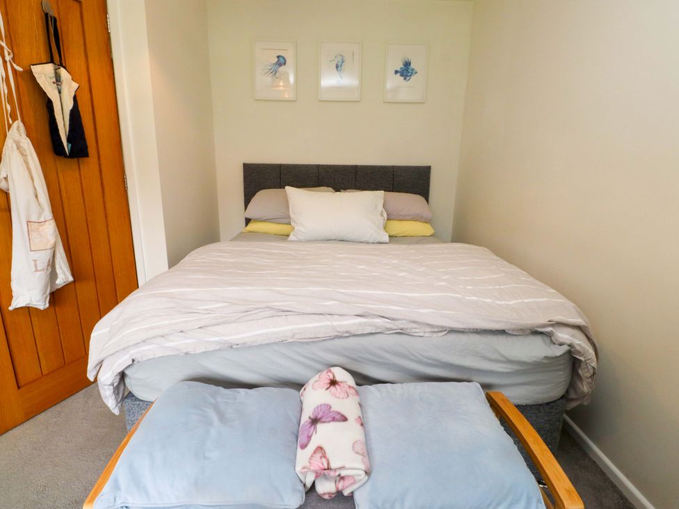 A bedroom with a bed and wall art at 7 Sisial Y Mor Rhosneigr