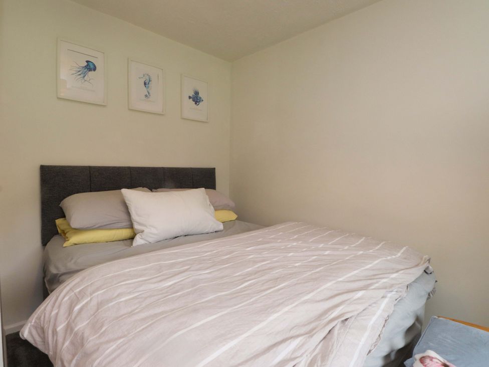 A bedroom with a bed and wall art at 7 Sisial Y Mor Rhosneigr