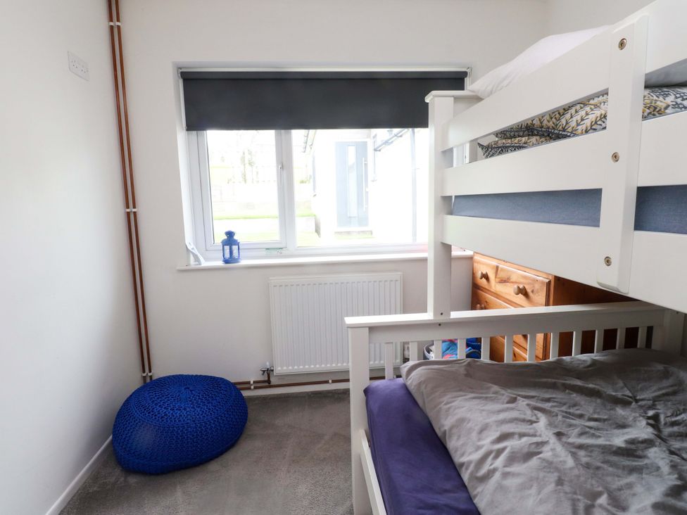 A bedroom with bunk bed and chest of drawers at 7 Sisial Y Mor in Rhosneigr