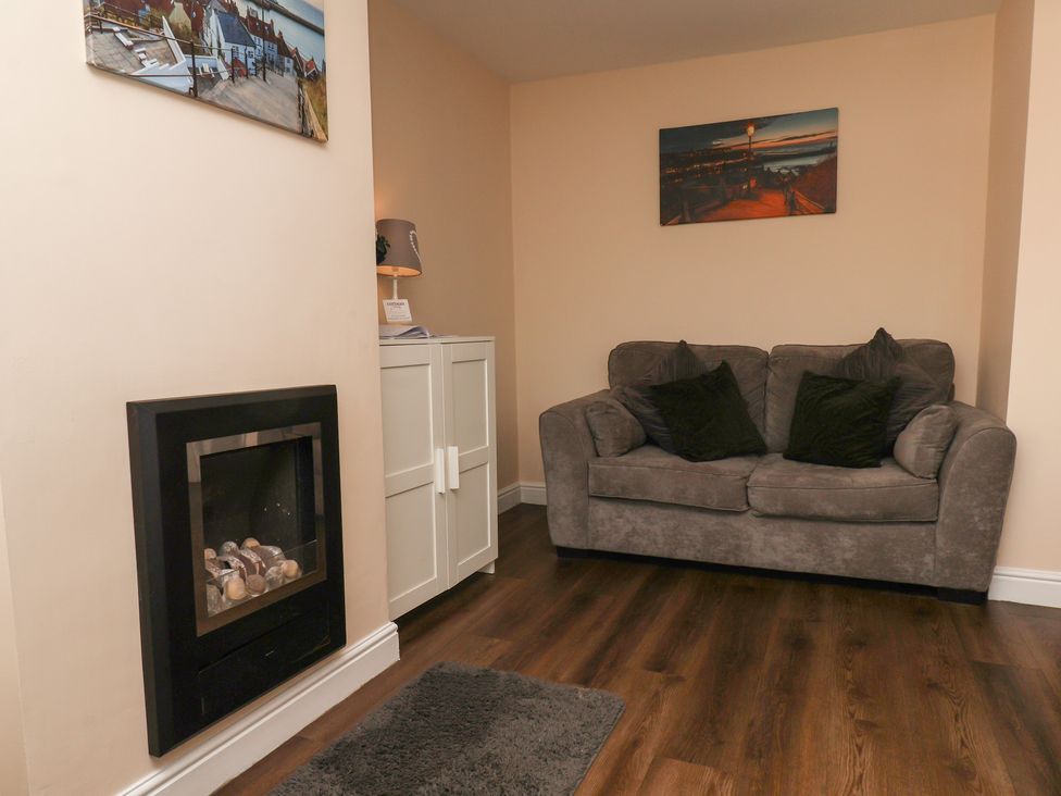 A living room with a sofa and fireplace at Marina Side in Whitby