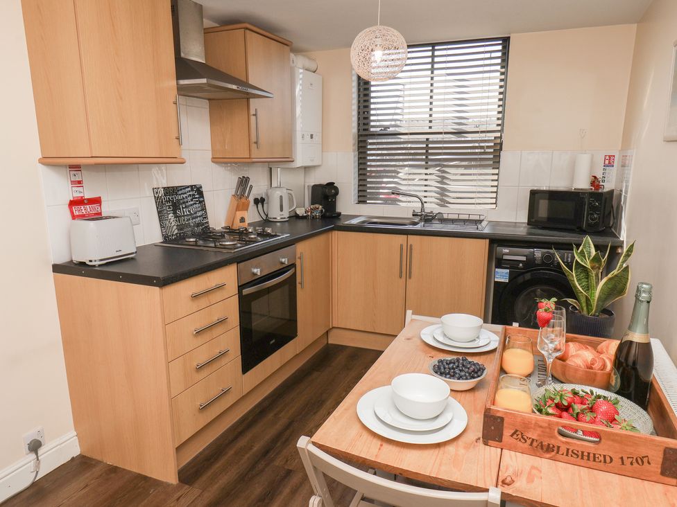 A kitchen with appliances and a dining table at Marina Side in Whitby