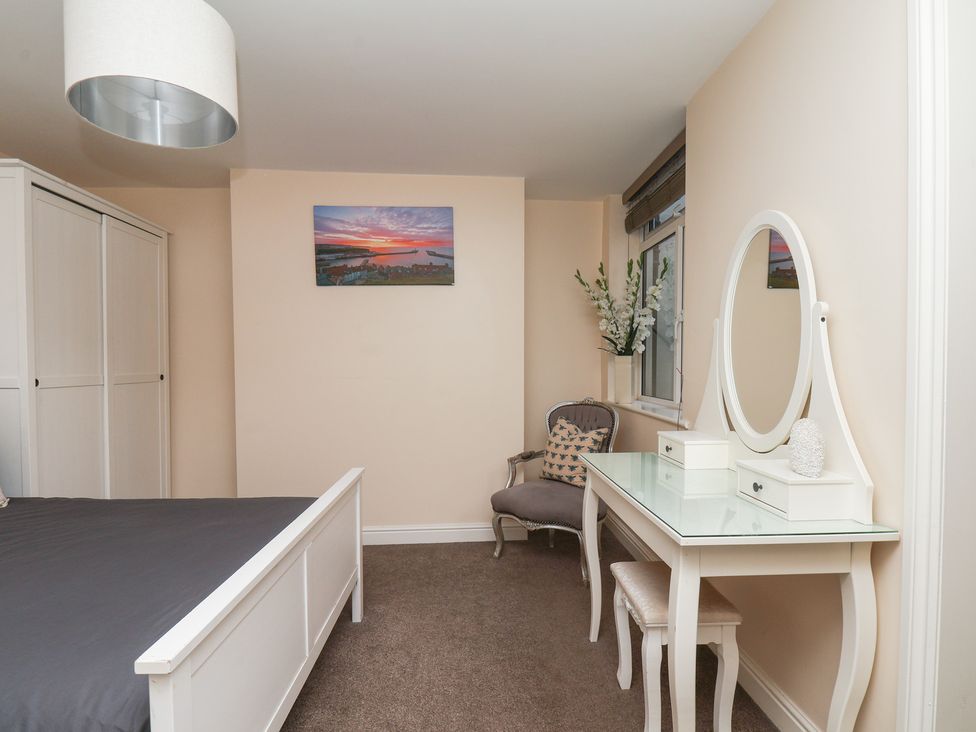 A bedroom with a bed and wardrobe at Marina Side in Whitby