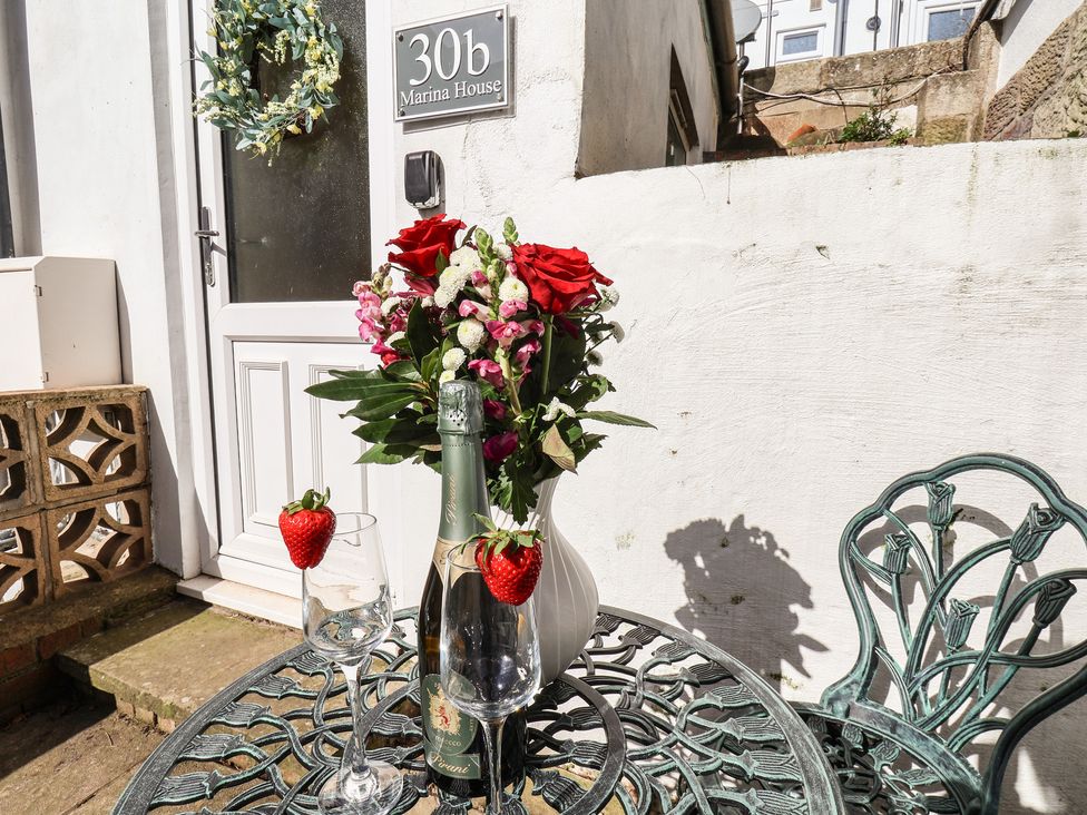 An outdoor table with flowers and drinks at Marina House in Whitby