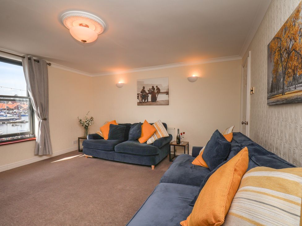 A living room with sofas and wall art at Marina House in Whitby