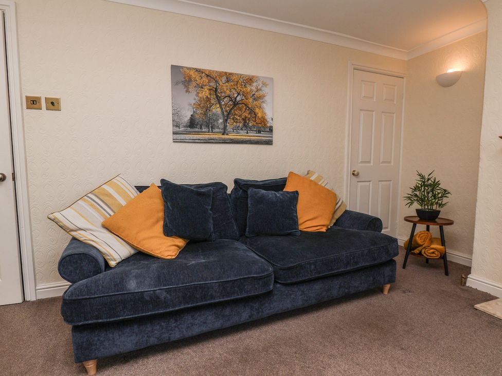 A living room with a sofa and wall art at Marina House in Whitby