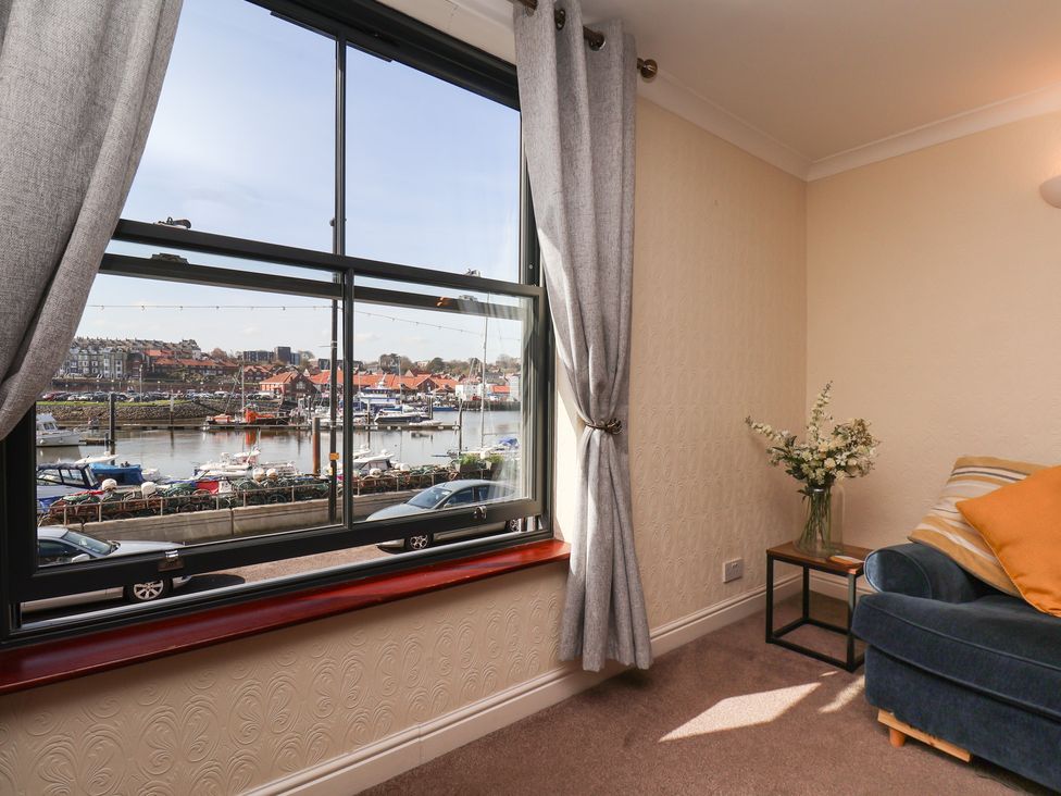 A living room with a view of a harbor at Marina House in Whitby