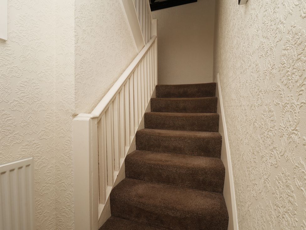 A staircase with carpet and handrail at Marina House in Whitby