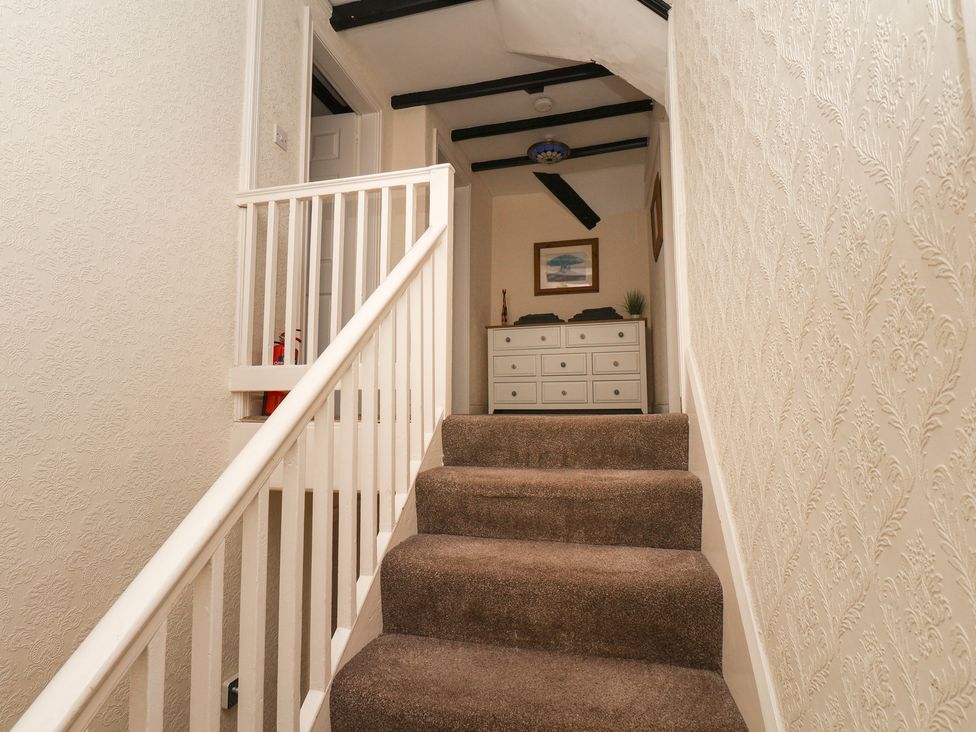 A staircase with a dresser in the hallway at Marina House in Whitby