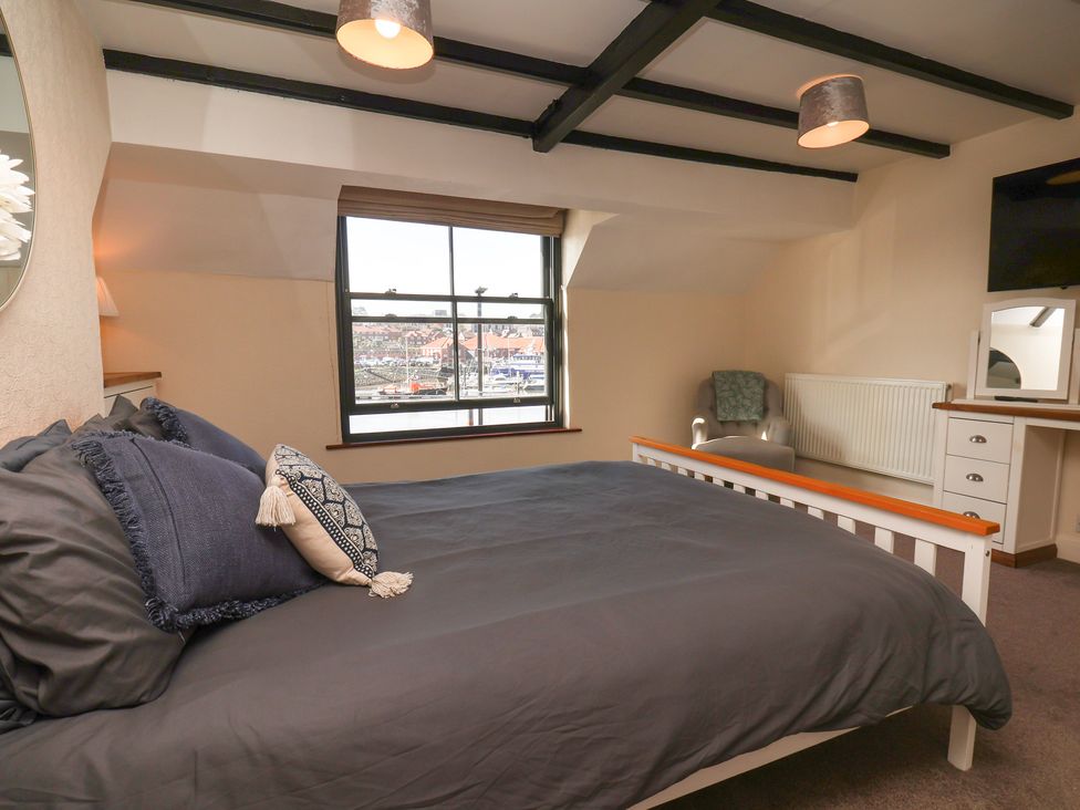 A bedroom with a bed and desk at Marina House in Whitby