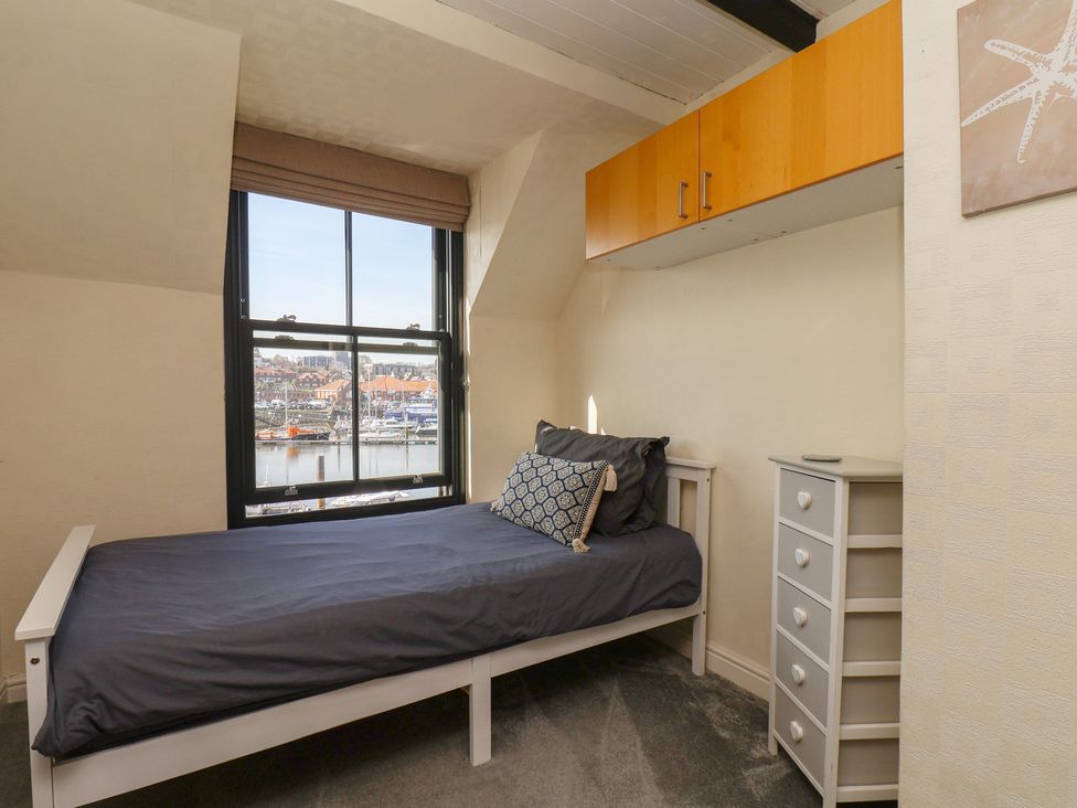 A bedroom with a bed and dresser at Marina House in Whitby