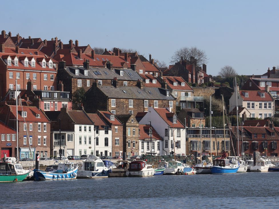 A view of a harbor with boats and buildings in Whitby
