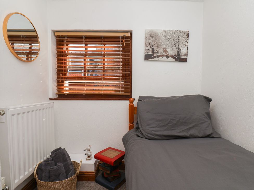 A bedroom with a bed and window at Bishop's Cottage in Whitby