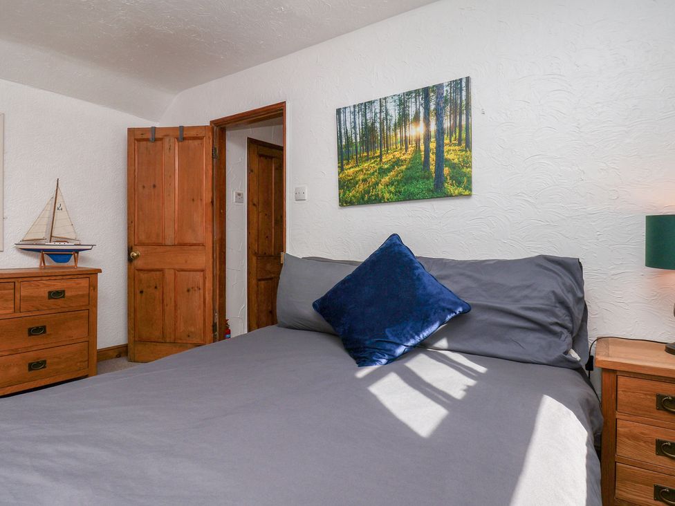 A bedroom with a bed and wooden furniture at Bishop's Cottage in Whitby