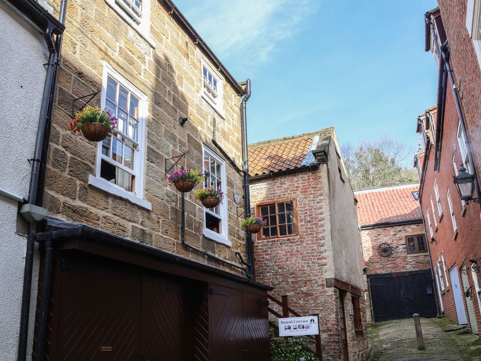 Exterior view of buildings with flower baskets at Bishop's Cottage in Whitby