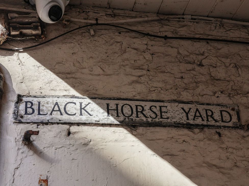A sign reading BLACK HORSE YARD on a wall in Whitby
