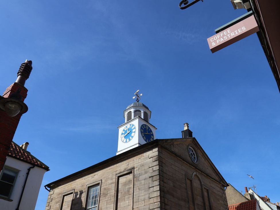 A clock tower building with a coffee and pastries sign at Bishop's Cottage Whitby
