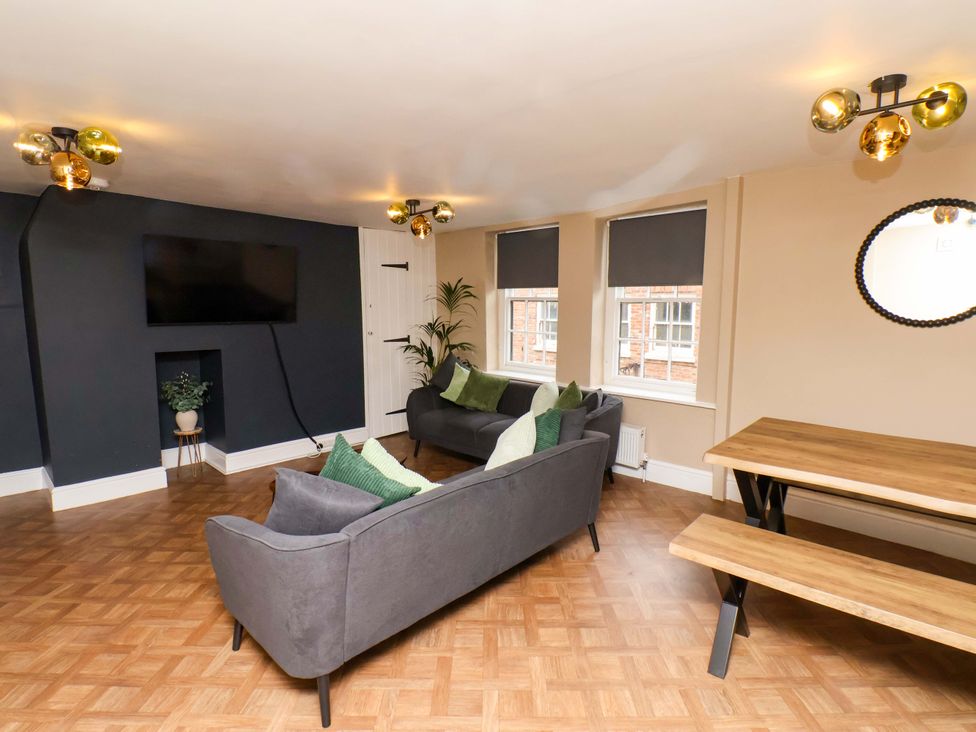 A living room with a sofa, table, and television at G's Loft in Whitby
