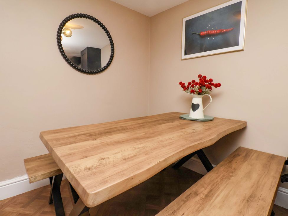 A dining room with a wooden table and a mirror at G's Loft in Whitby