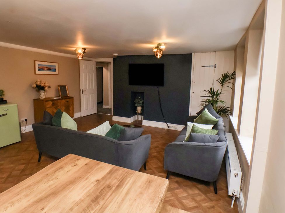 A living room with sofas and a table at G's Loft in Whitby