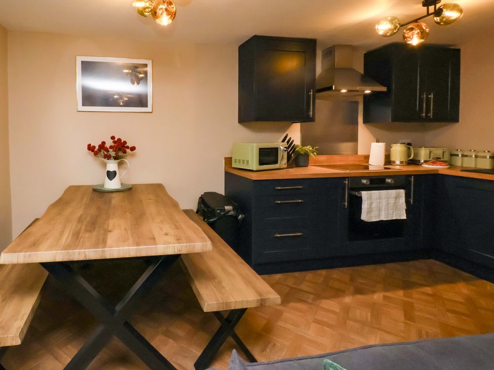 A kitchen with a table and benches at G's Loft in Whitby