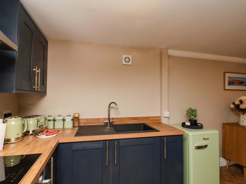 A kitchen with a sink and fridge at G's Loft in Whitby