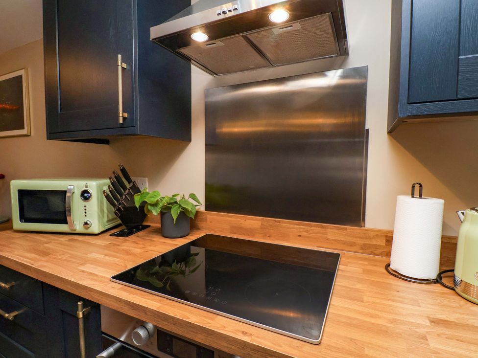A kitchen with a microwave and induction cooktop at G's Loft in Whitby