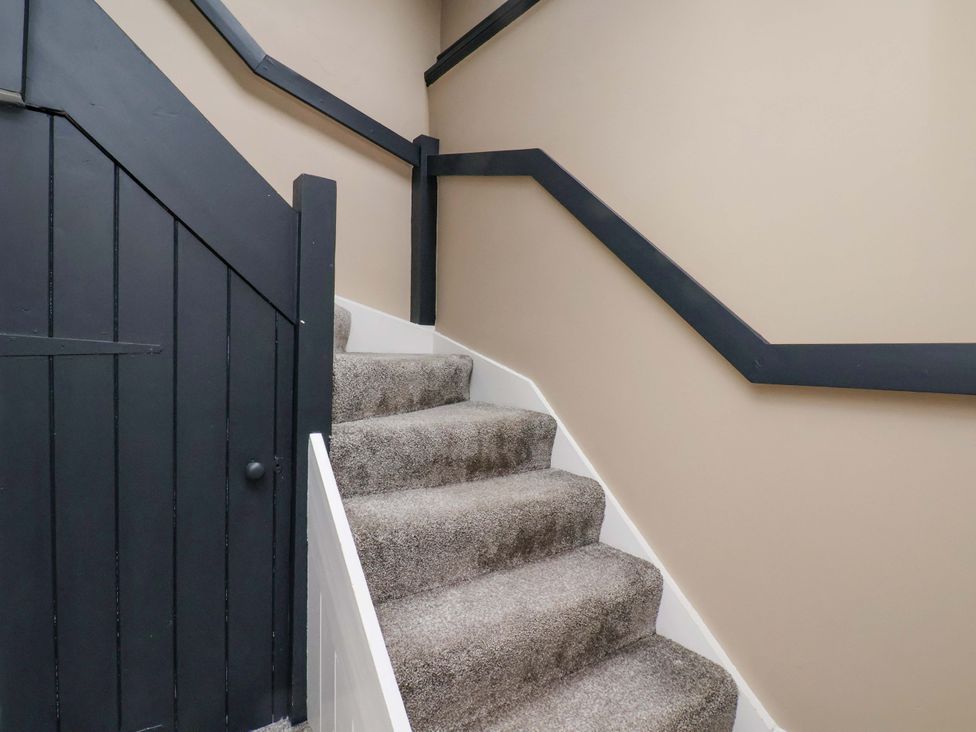 A staircase with carpet and a door at G's Loft in Whitby