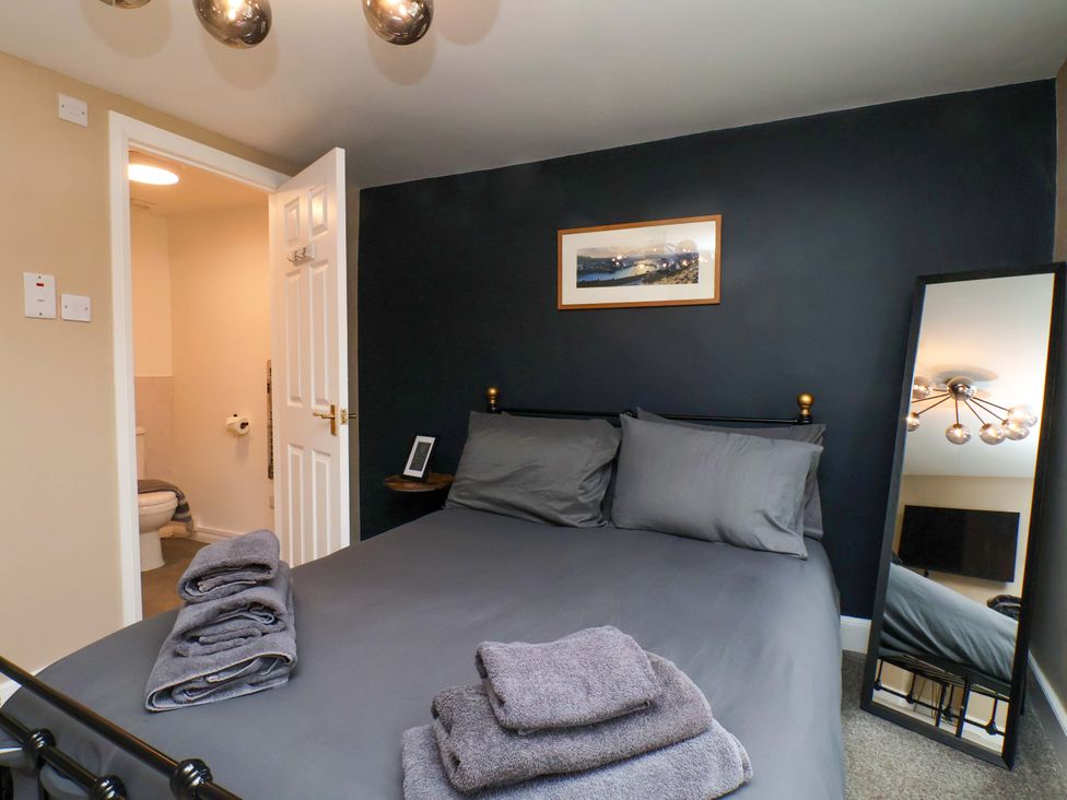 A bedroom with a bed and towels at G's Loft in Whitby