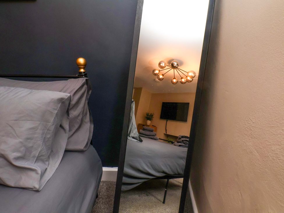 A bedroom with a bed and television at G's Loft in Whitby