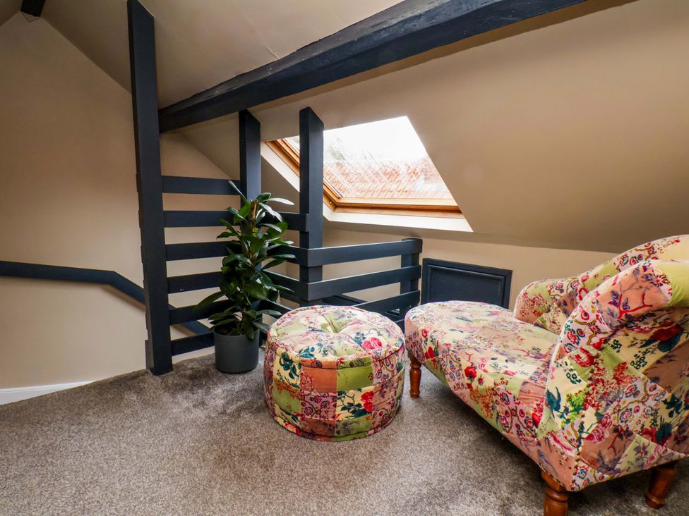 A snug area with a chair and ottoman at G's Loft in Whitby