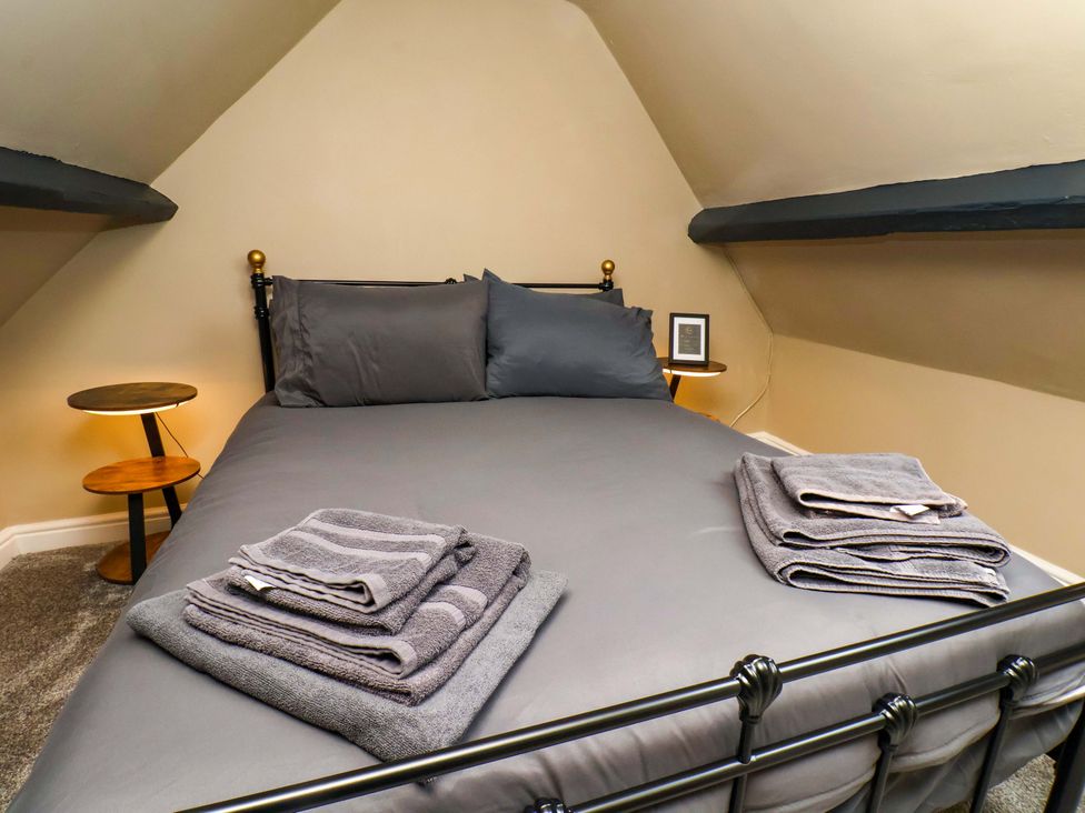 A bedroom with a bed and towels arranged at G's Loft in Whitby