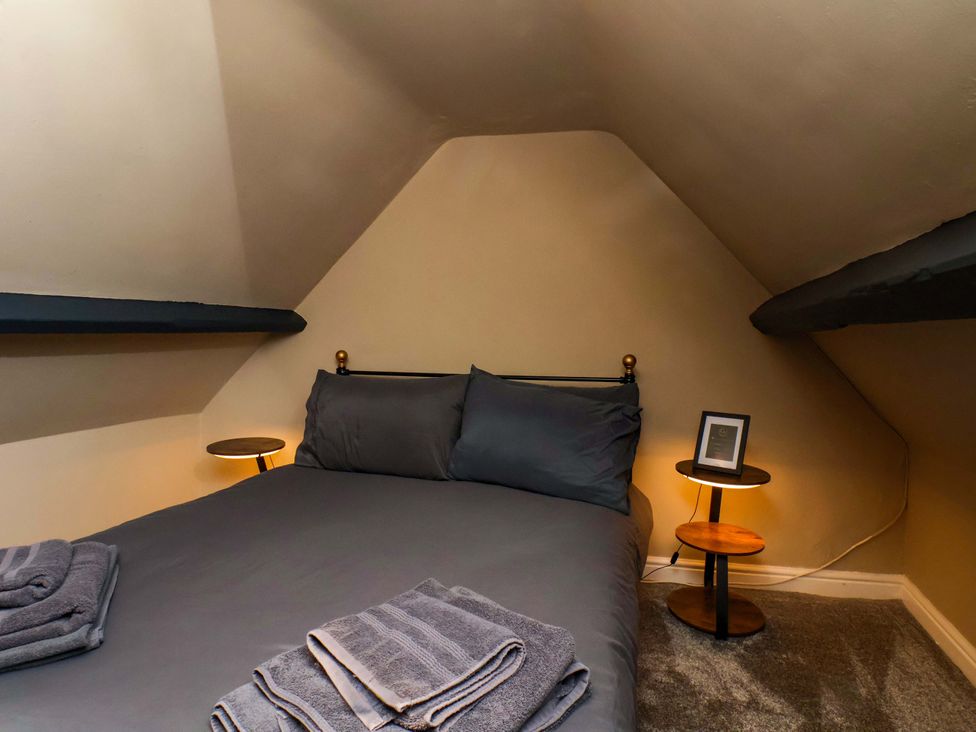 A bedroom with a bed and bedside tables at G's Loft in Whitby