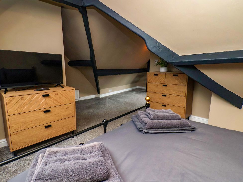 A bedroom with a television and dresser at G's Loft in Whitby