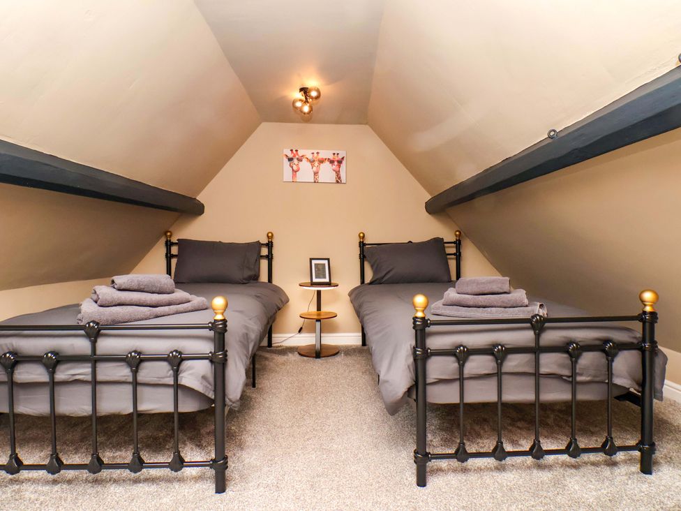 A bedroom with two beds and a nightstand at G's Loft in Whitby