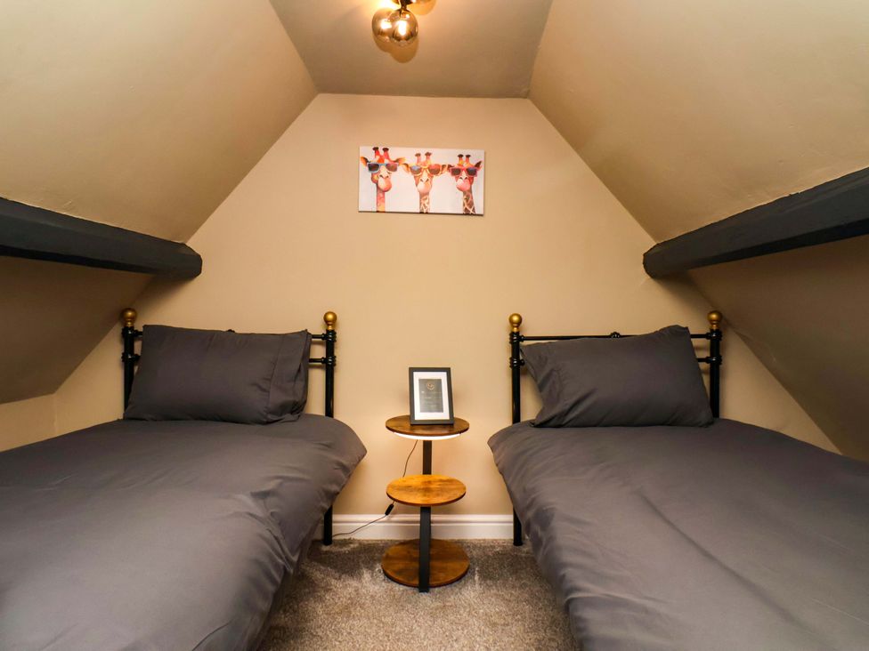 A bedroom with two beds and a small table at G's Loft in Whitby