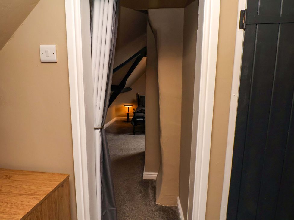 A hallway with a chair and light at G's Loft in Whitby