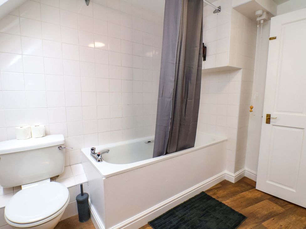 A bathroom with a bathtub and toilet at G's Loft in Whitby